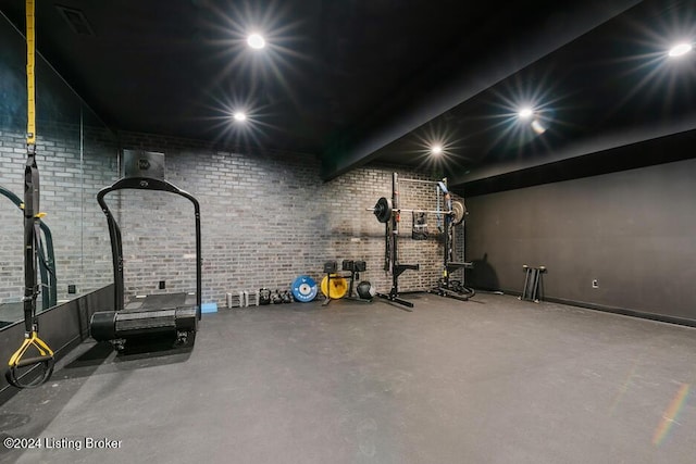 exercise room featuring brick wall