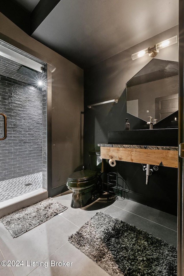 bathroom with tile patterned floors, toilet, and tiled shower