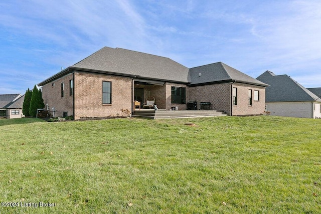 rear view of property with a yard and a patio