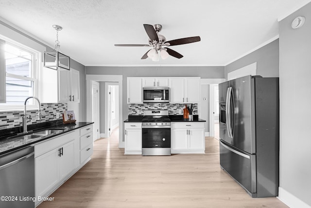 kitchen featuring pendant lighting, sink, ceiling fan, white cabinetry, and stainless steel appliances