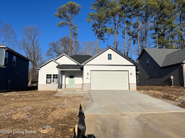 view of front of home with driveway, a garage, and brick siding