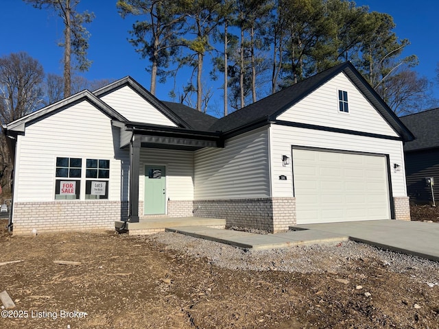 view of front of home featuring a garage, concrete driveway, and brick siding