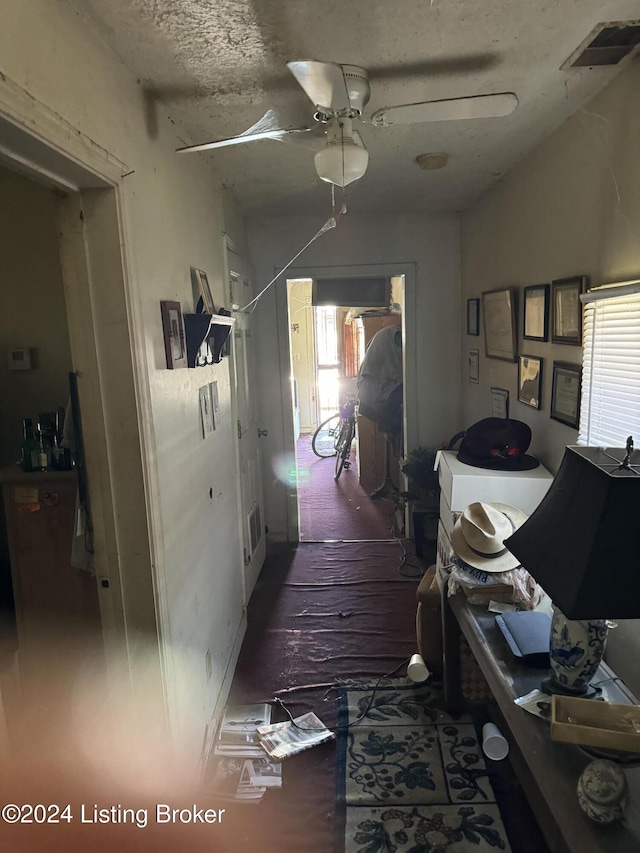 hall featuring a textured ceiling