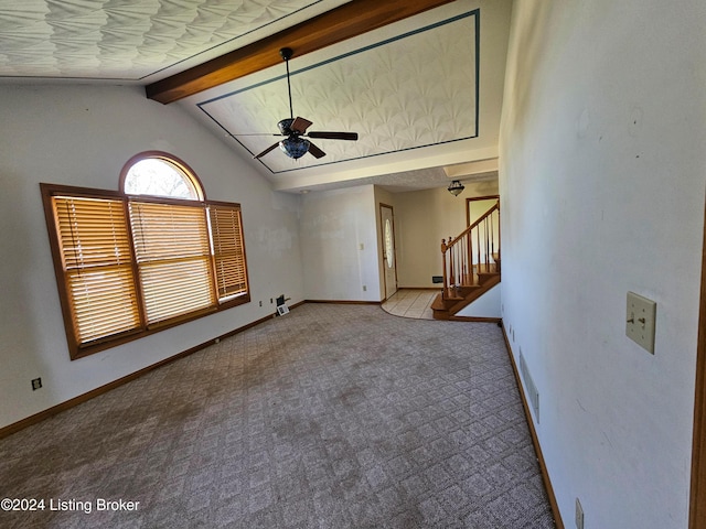 unfurnished living room featuring lofted ceiling with beams, ceiling fan, and light colored carpet