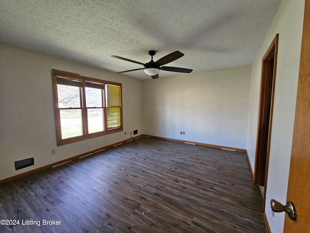 empty room featuring ceiling fan, dark wood-type flooring, and a textured ceiling