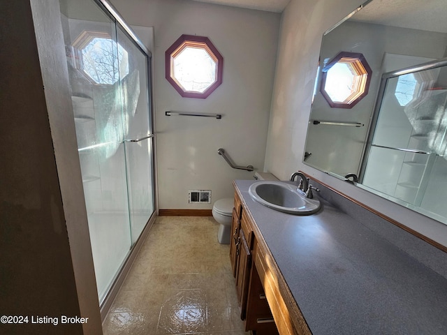 bathroom featuring vanity, toilet, and walk in shower