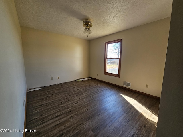 empty room featuring dark hardwood / wood-style flooring and a textured ceiling