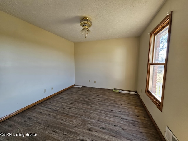 empty room with a textured ceiling, dark hardwood / wood-style flooring, and ceiling fan