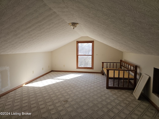 additional living space with a textured ceiling, carpet, and vaulted ceiling