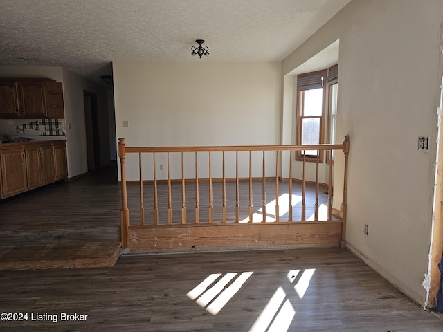 spare room featuring dark hardwood / wood-style flooring and a textured ceiling