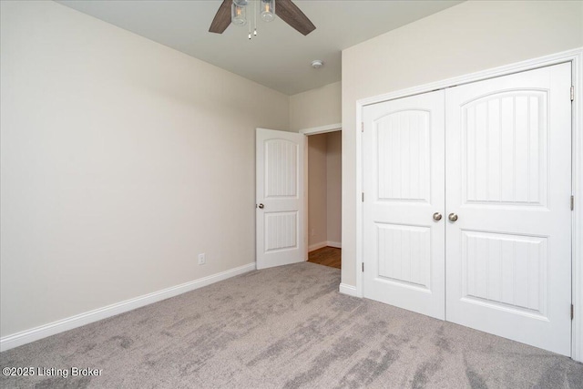 unfurnished bedroom featuring light colored carpet, a closet, and ceiling fan