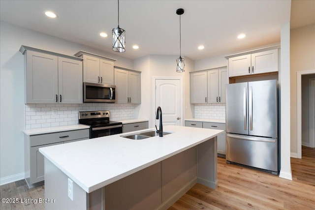 kitchen featuring hanging light fixtures, gray cabinets, sink, and appliances with stainless steel finishes