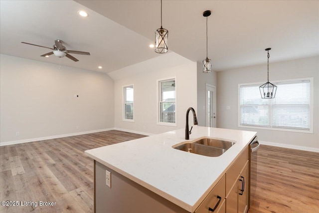 kitchen featuring a center island with sink, a wealth of natural light, sink, and hanging light fixtures