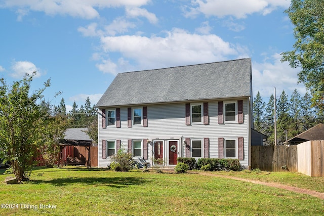 colonial-style house featuring a front yard