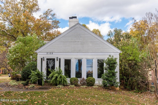 view of side of property with a lawn