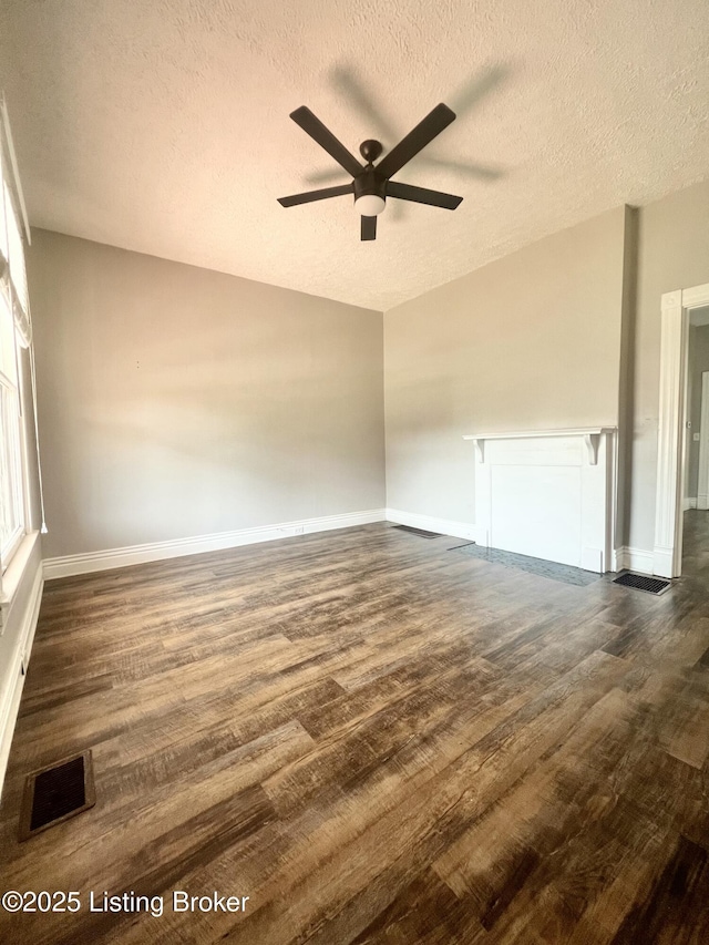 unfurnished room featuring a textured ceiling, dark hardwood / wood-style floors, and ceiling fan