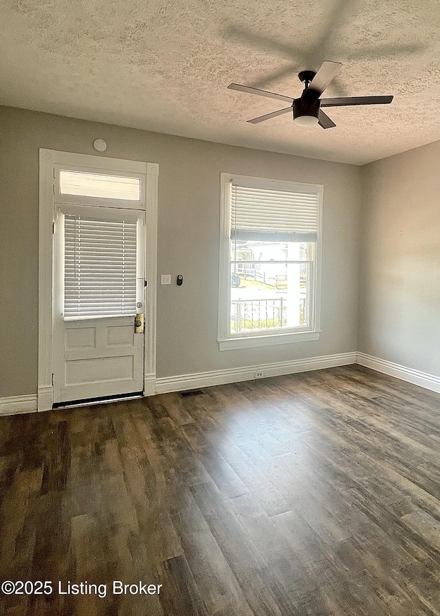 entrance foyer with dark hardwood / wood-style flooring, a textured ceiling, and ceiling fan