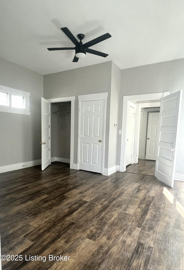 unfurnished bedroom featuring dark wood-type flooring, a ceiling fan, and baseboards