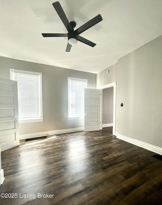 spare room with ceiling fan and dark wood-type flooring