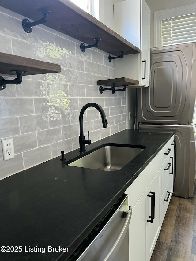 kitchen with tasteful backsplash, stainless steel dishwasher, sink, white cabinets, and dark hardwood / wood-style floors