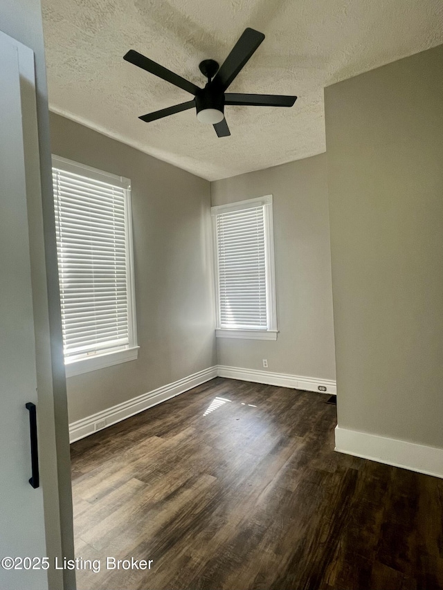 spare room featuring ceiling fan, dark wood-type flooring, and a textured ceiling