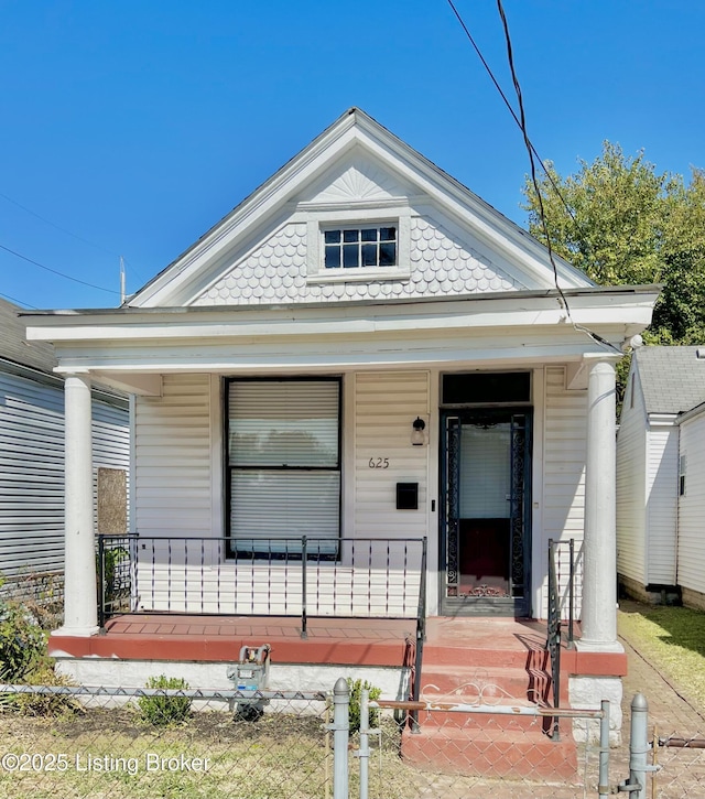 view of front of home with a porch and fence