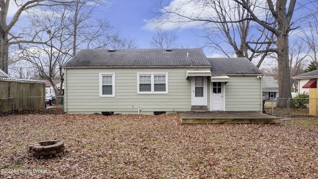 rear view of house with a fire pit and a wooden deck