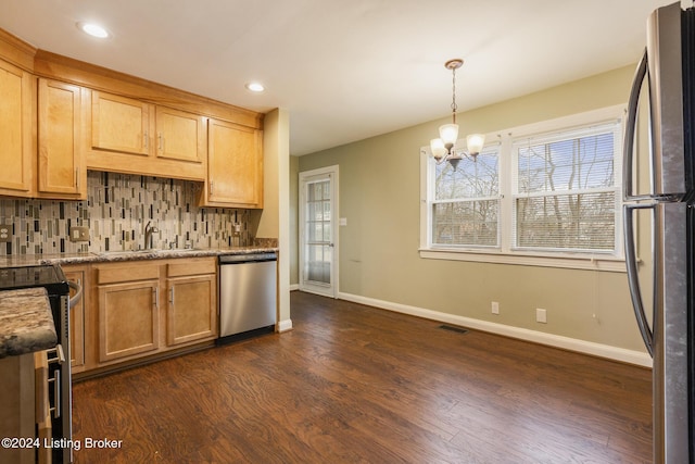 kitchen featuring sink, an inviting chandelier, pendant lighting, decorative backsplash, and appliances with stainless steel finishes