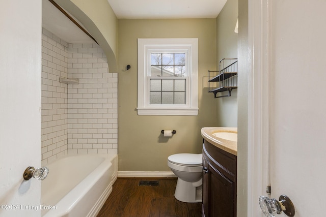 full bathroom featuring vanity, hardwood / wood-style flooring, toilet, and tiled shower / bath combo