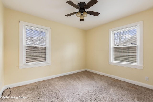 carpeted spare room featuring ceiling fan and a healthy amount of sunlight