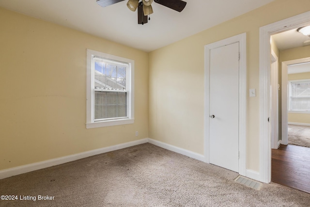 unfurnished bedroom featuring carpet, ceiling fan, and a closet