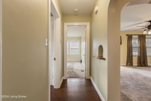 hallway featuring dark carpet