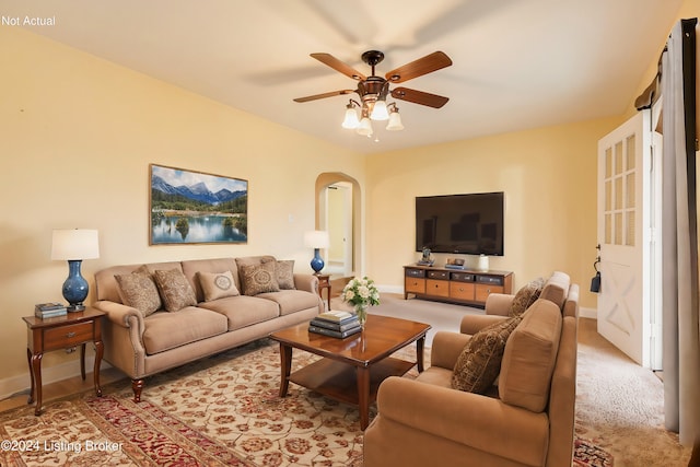 carpeted living room featuring ceiling fan