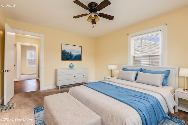 carpeted bedroom with multiple windows and ceiling fan