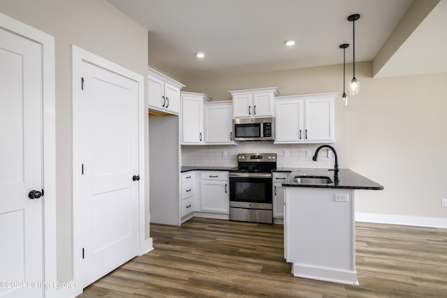 kitchen featuring pendant lighting, sink, decorative backsplash, appliances with stainless steel finishes, and white cabinetry