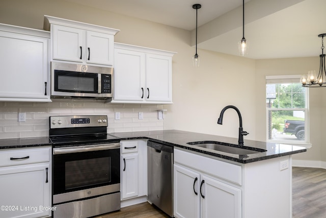 kitchen with appliances with stainless steel finishes, white cabinetry, pendant lighting, and sink