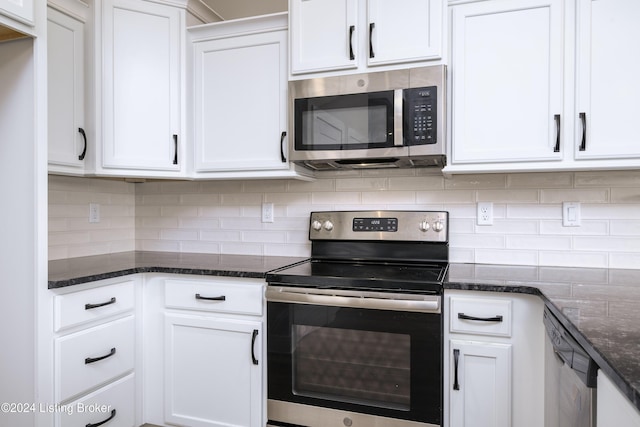 kitchen featuring dark stone counters, backsplash, white cabinets, and stainless steel appliances