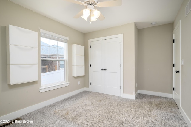 unfurnished bedroom with ceiling fan, a closet, and light carpet