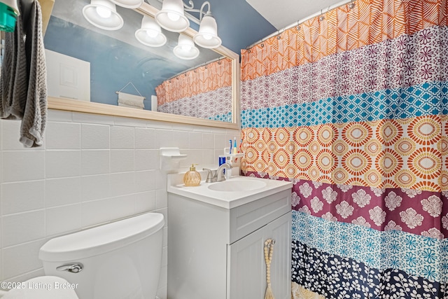 bathroom with vanity, tile walls, and toilet