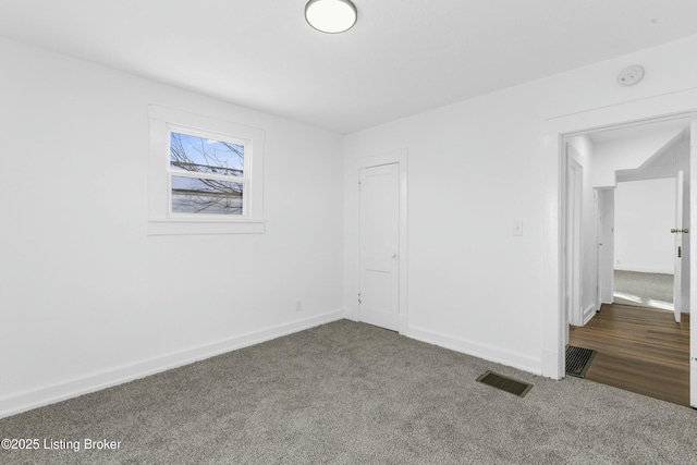 unfurnished bedroom with visible vents, carpet flooring, and baseboards