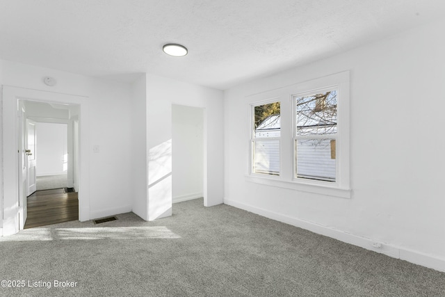 empty room featuring a textured ceiling and carpet