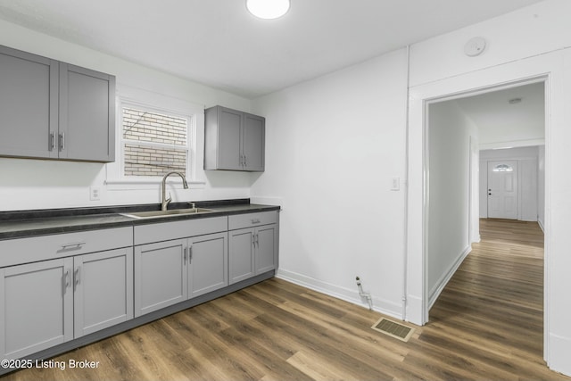 kitchen featuring dark hardwood / wood-style flooring, sink, and gray cabinetry