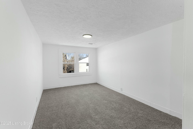 spare room featuring carpet and a textured ceiling