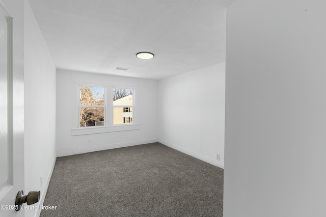 spare room with visible vents, carpet, and baseboards