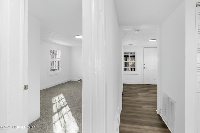 hallway featuring visible vents and baseboards