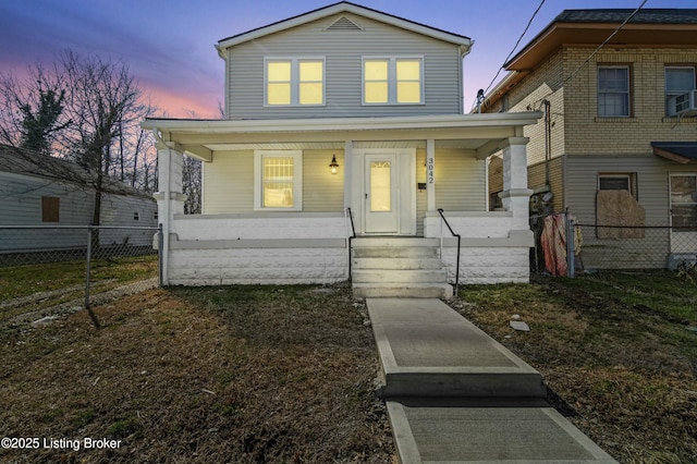 view of front of home featuring covered porch and fence