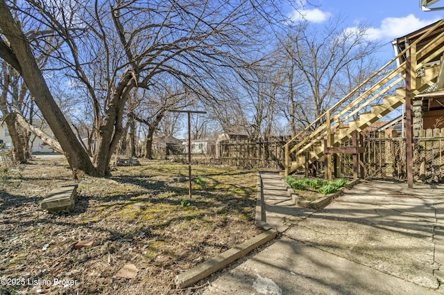 view of yard featuring stairs and fence