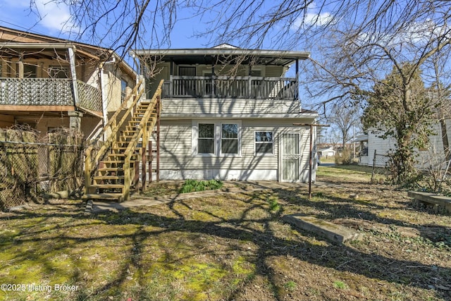 rear view of house featuring stairs and fence