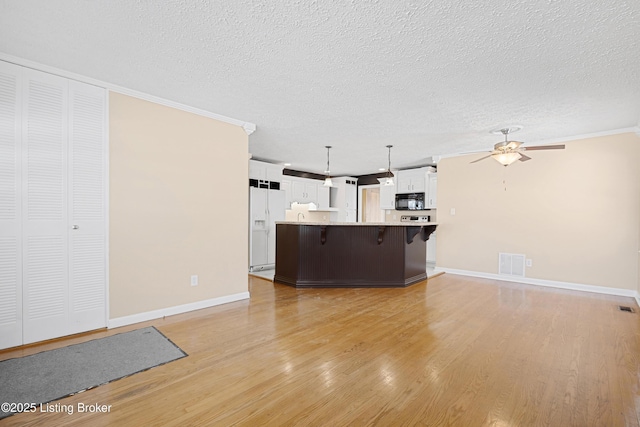 unfurnished living room with ceiling fan, light hardwood / wood-style flooring, crown molding, and a textured ceiling