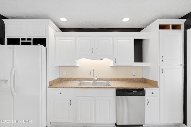 kitchen featuring white refrigerator with ice dispenser, white cabinets, stainless steel dishwasher, and sink